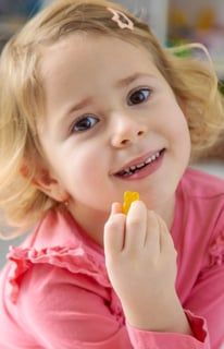 Child eating gummy_shutterstock_2731962741